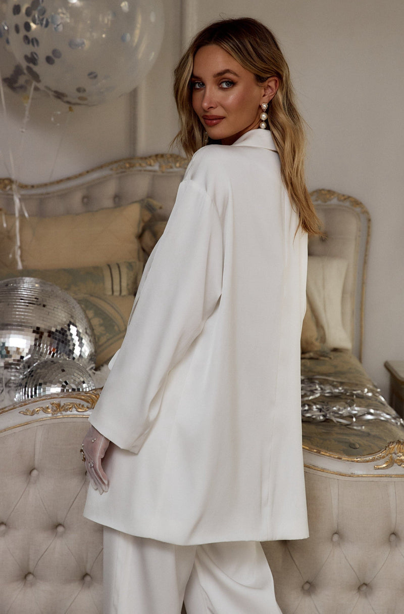 Model shows the back of the Halley white satin blazer in a glam bridal suite.
