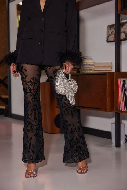 Back view of the black velvet flare pants showing the silhouette and fit.