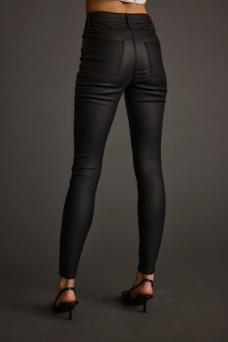 Lifestyle shot of the black pants styled for day-to-night versatility.