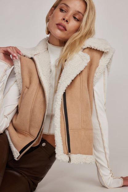 Beige sherpa lined vest worn open, showing faux fur collar and zip front.