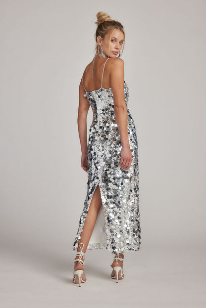 Back view of silver paillette sequin maxi dress with thin straps and rear leg slit.