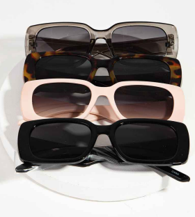 Four rectangle sunglasses in grey, tortoise, pink, and black stacked on a pale surface.