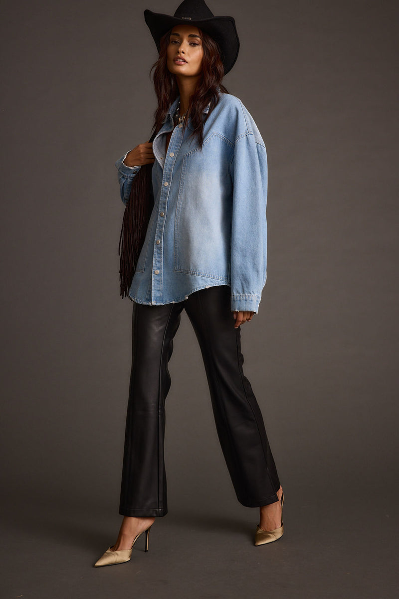 Back view of the black vegan leather and leather flare pants showing the silhouette and fit.