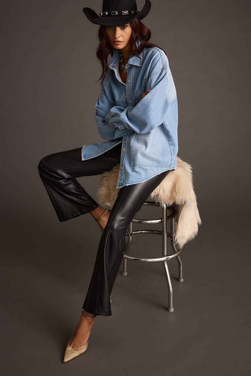 Lifestyle shot of the black flare pants styled for day-to-night versatility.