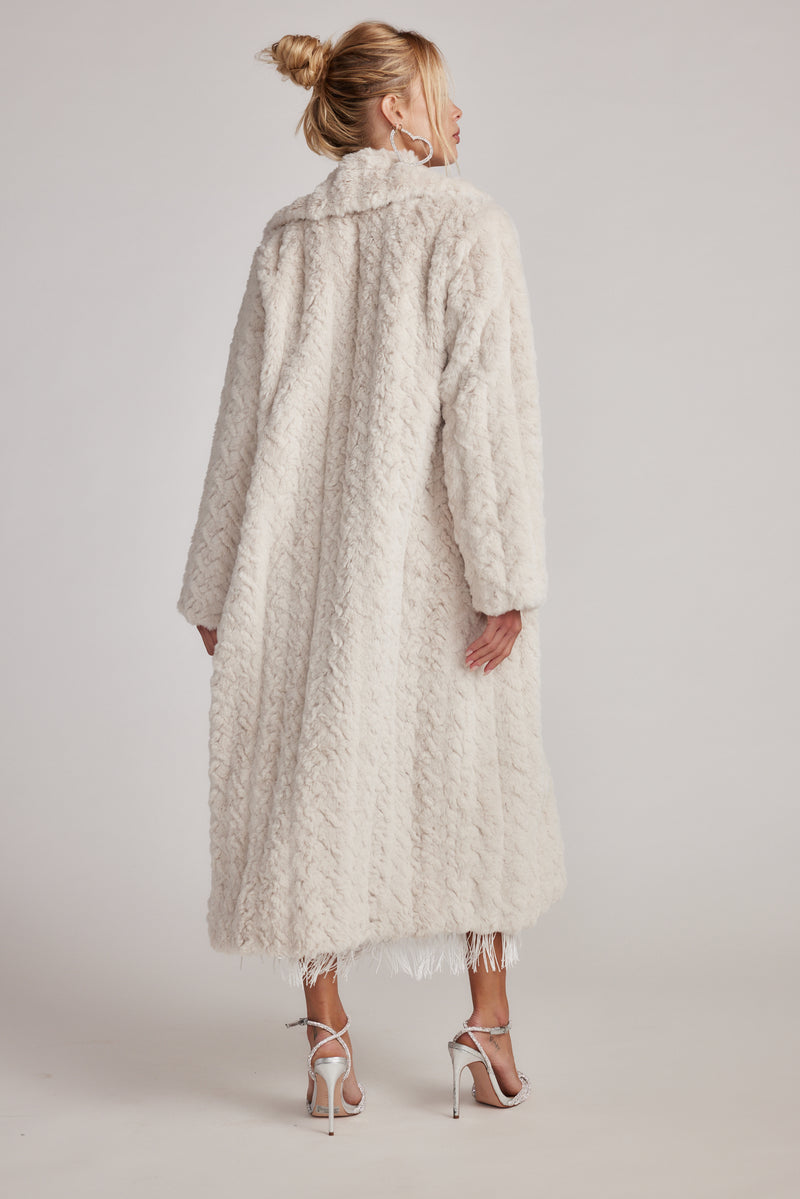 Back view of the cream jacket showing the silhouette and fit.