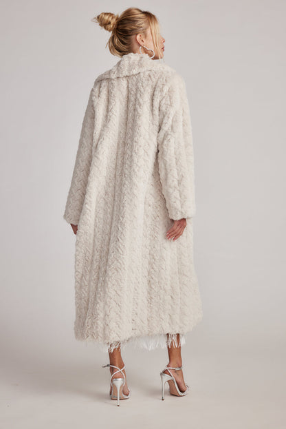 Back view of the cream jacket showing the silhouette and fit.